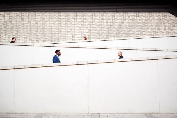 Graphic Shot Of Commuters Walking To Work Along Concrete Walkway Outside Building Graphic Shot Of Commuters Walking To Work Along Concrete Walkway Outside Building